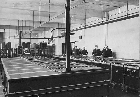 A view of the Battery Room. The 'A' batteries in the foreground and the 3 sets of 'B' batteries can be seen at the rear. Staff from left to right: J. T. Barnes, J. Sunderwall, C. J. Jones and G. D. Line.
